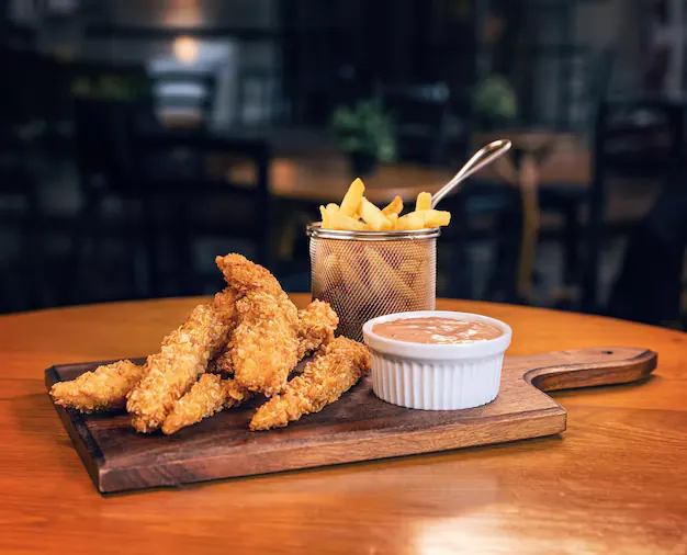 Crispy chicken fingers with fries and a dipping sauce